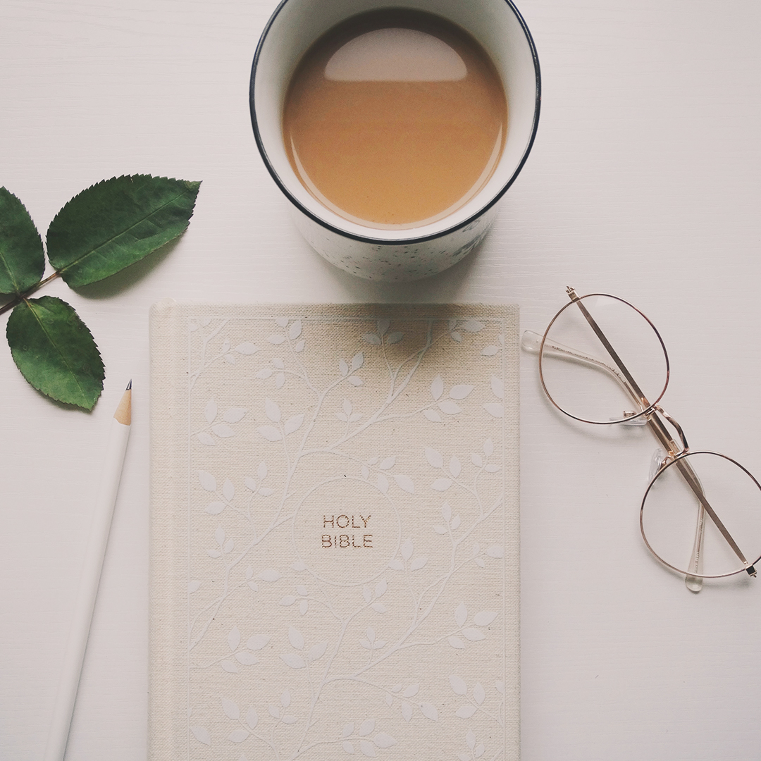 Holy Bible on a table with a mug of coffee and a pair of glasses